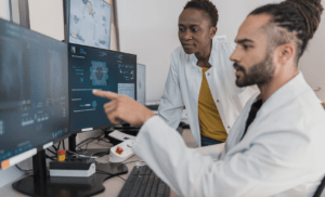 Healthcare workers analyzing trends on a computer screen.